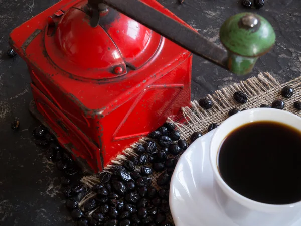 Kaffeetasse mit roter Kaffeemühle und Bohnen — Stockfoto