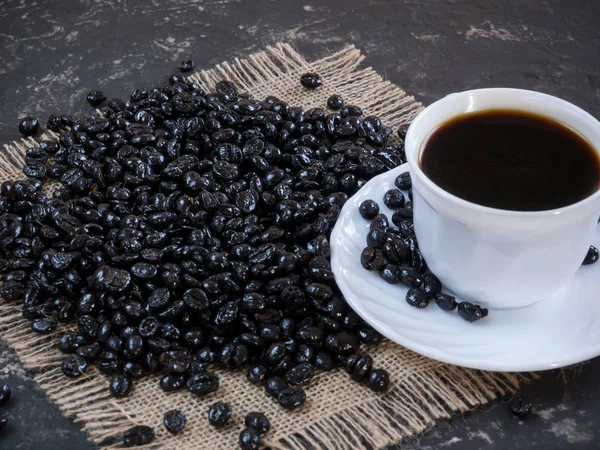 Kaffeetasse mit Kaffeebohnen auf dem Steintisch — Stockfoto