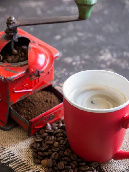 Vintage rote Kaffeemühle, rote Tasse, mit Kaffeebohnen — Stockfoto