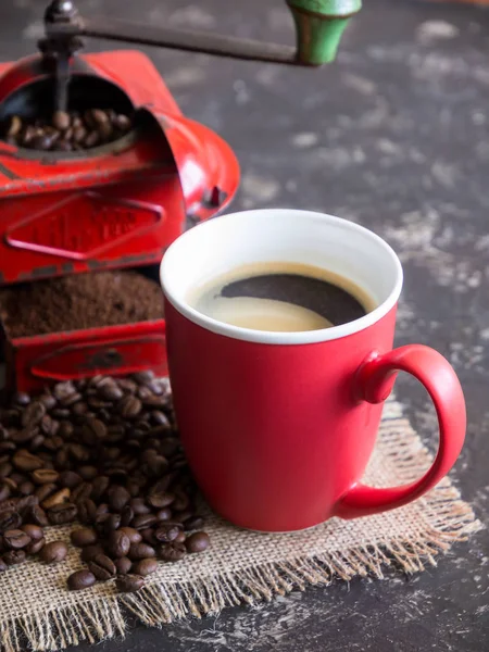 Vintage rote Kaffeemühle, rote Tasse, mit Kaffeebohnen — Stockfoto