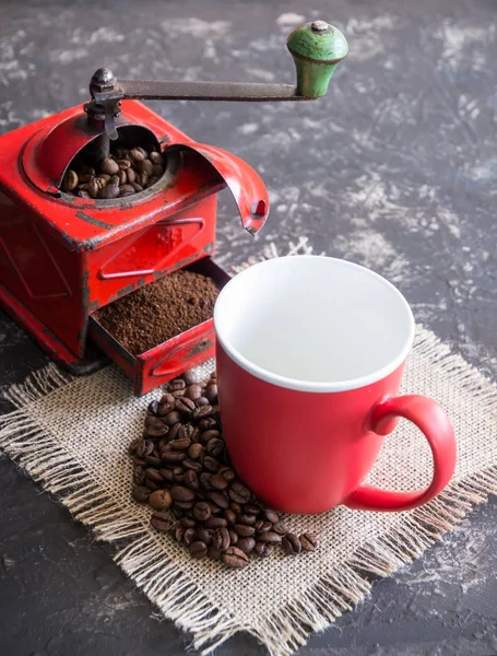 Vintage rote Kaffeemühle, rote Tasse, mit Kaffeebohnen — Stockfoto