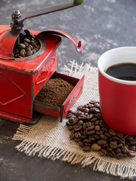 Vintage rote Kaffeemühle, rote Tasse, mit Kaffeebohnen — Stockfoto