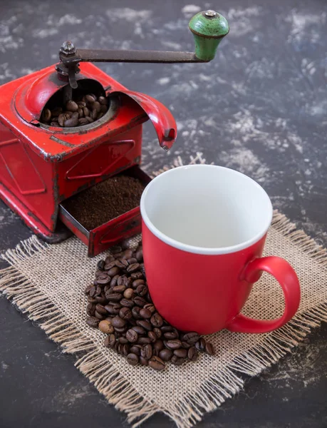 Kırmızı kahve öğütücüsü, kahve çekirdekli kırmızı bardak.