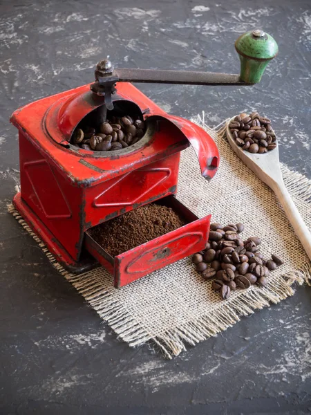 vintage red coffee grinder and coffee beans with wooden spoon