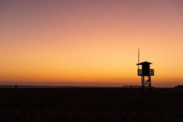 Silhouette della casa bagnino sulla spiaggia di Isla canela, al tramonto. Huelva, Andalusia, Spagna . — Foto Stock