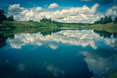 Cumulus beyaz bulutları ve ağaçlarıyla yaz manzarası