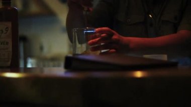 Barmen şişede içki karıştırıyor.