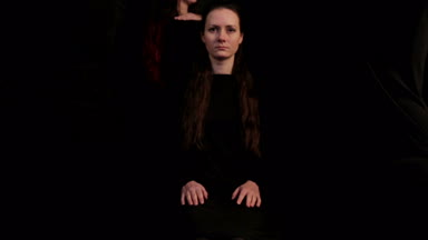 Bir sahne tiyatro üretim, kız bir sandalyeye oturur. Kız bir daire etrafında yürüyüş kadınların bir sandalyede oturur. 