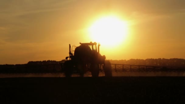 夕暮れ時のフィールドに化学物質を散布トラクターです トウモロコシの日の夕暮れ時 フィールドにおける施肥 — ストック動画