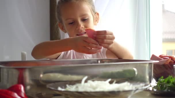 一个小女孩的肖像帮助她的母亲在厨房里 女儿帮助妈妈在比萨制作4K 孩子学会烹调食物 — 图库视频影像
