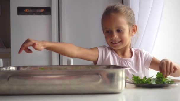 台所で母を手伝います少女の肖像画 娘はママ のビデオ作りに役立ちます 食品を調理することを学ぶ子 — ストック動画