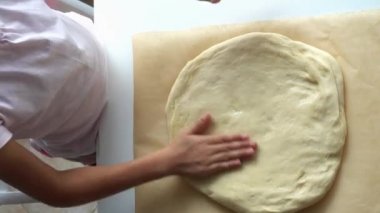 Küçük bir kız hamur pizza için kneads. Çocuk pasta hamuru 4 k video hazırlanmasında yardımcı olur.. 