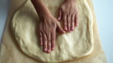 Bebek eller bir pizza hamuru 4k video yakın çekim. Çocuk elleri ile pişirme için gözleme hamur rulo. 