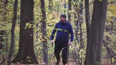 Yavaş aşağı bir balta ile ormanda sakallı adam. Ormandaki ağaçlar doğrama Forester. Ağır çekim. 