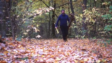 Portre portre bir korucu, bacaklar, balta, ayakkabılar. Bir adam ormandaki bir balta ile yakın çekimler. 