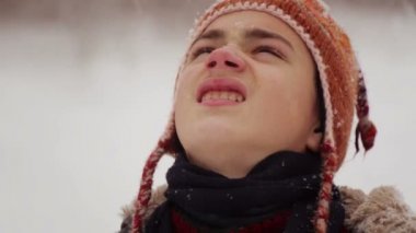 Çocuk gökten düşen kar bakarak, yakın bir yüzüdür. Kar yağışı kışın bir çocuk portresi. 