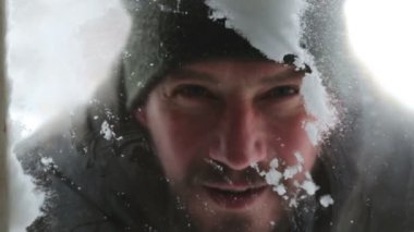 Bir adam kar mendil ve kışın donmuş camına çizer. Yakın çekim bir avludan bir pencereden bakan bir erkek portresi. 