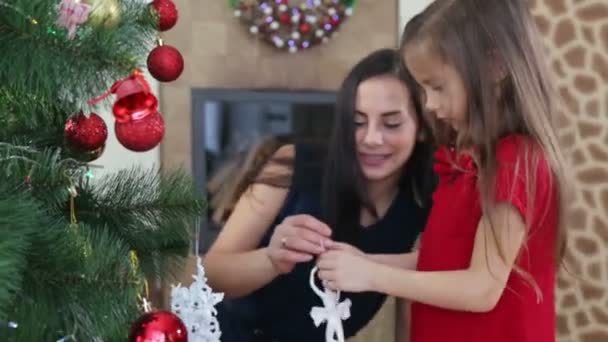 母女俩为新的一年装饰圣诞树 一个带着一个女孩的女人装饰圣诞树 — 图库视频影像