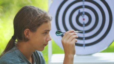 Dart oynayan genç bir çocuğun portresi. Bir çocuk açık dart oyunu oynar. 