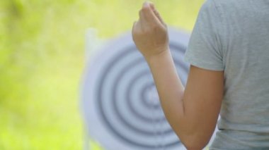 Dart için dart ile closeup kız eli. Eldeki kız doğada dart için dart tutar. 