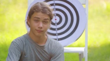Dart oynayan genç bir çocuğun portresi. Bir çocuk açık dart oyunu oynar. 