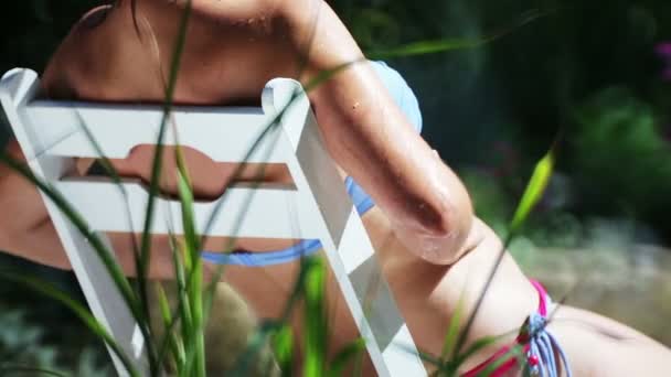 熱帯地方の別荘で休んでいる美しい若い女の子 女性は休暇で日光浴を取ります — ストック動画