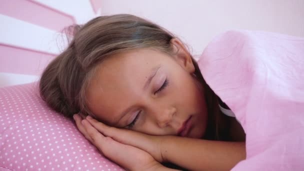 小さな女の子はピンクのベッドで眠る ベッドで朝起きる赤ちゃんの肖像画 — ストック動画