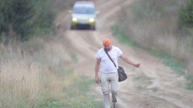 Köy yolunda otostop çeken bir adam. Genç sakallı bir adam tarlada bir arabayı durdurur. Seyahat arkadaşı, gezgin, gezgin. 