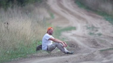 Köy yolunda otostop çeken bir adam. Genç sakallı bir adam tarlada bir arabayı durdurur. Seyahat arkadaşı, gezgin, gezgin. 