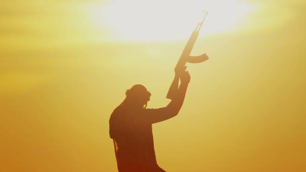 日没の日にカラシニコフとイスラム戦士 イスラム教徒の戦闘機は日没時に機関銃で訓練している — ストック動画