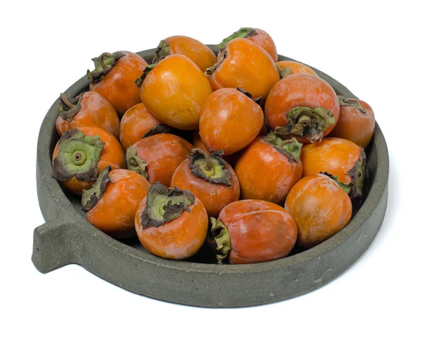 Persimmons on concrete dish isolated on white background — Stock Photo, Image