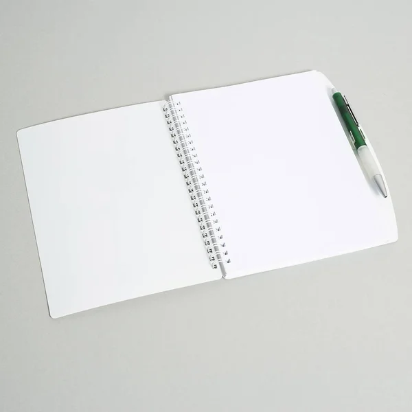 Open notebook with pen on white background