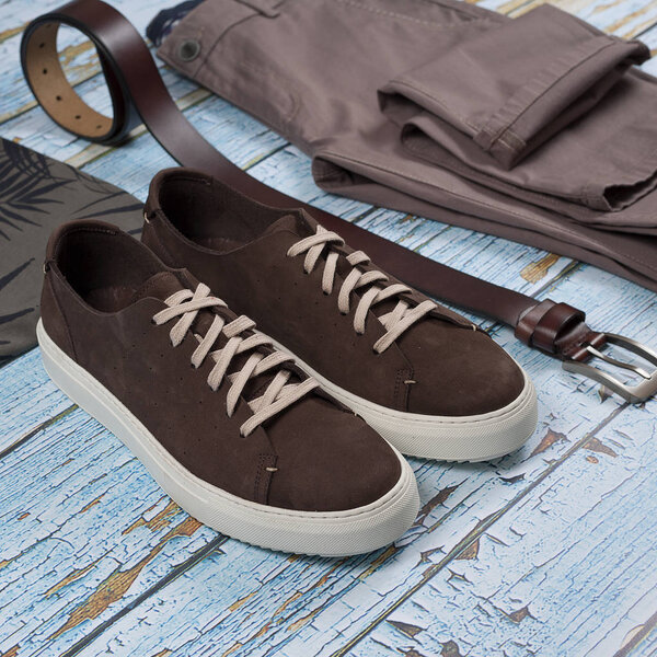 Men casual outfit. Men's shoes, clothing and accessories on wooden background - jeans, shirt, sneakers, belt. Top view. Flat lay