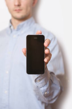 Casual adam duran beyaz arka plan boş telefon ekranını göstermeyi portresi