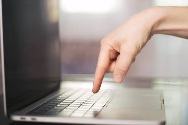 Bir tek parmak ile bulanık laptop klavye düğmesine basarak