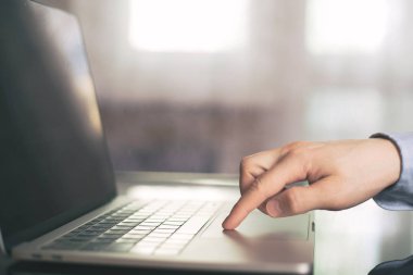 Bir tek parmak ile bulanık laptop klavye düğmesine basarak