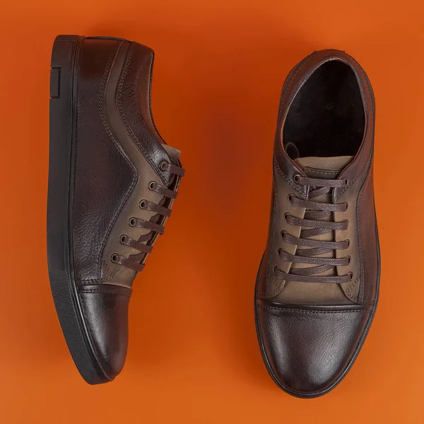 Brązowy buty trampki na pomarańczowym tle — Zdjęcie stockowe