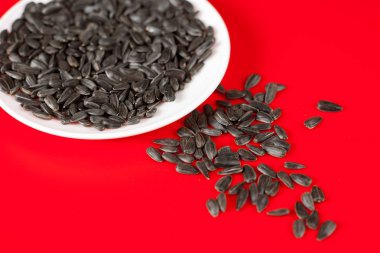 Kırmızı bir arka plan üzerinde siyah ayçiçeği çekirdeği. Üstten Görünüm