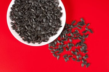 Kırmızı bir arka plan üzerinde siyah ayçiçeği çekirdeği. Üstten Görünüm