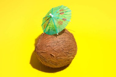 Yello izole bir kokteyl şemsiyesi ile Taze doğal hindistan cevizi