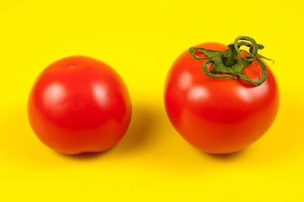 Tomate rouge fraîche avec tige verte sur fond jaune — Photo