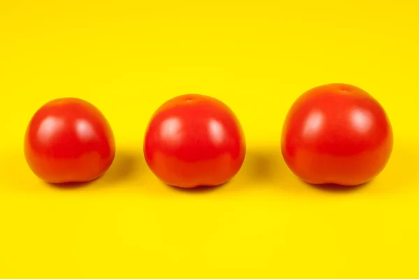 Piękne świeże pomidory izolowane na żółtym tle. — Zdjęcie stockowe