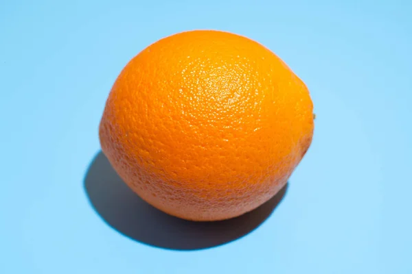 Зрізати соковитий апельсин на синьому фоні. Здорове харчування та дієта — стокове фото