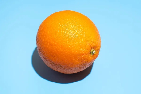 Ώριμο ζουμερό πορτοκαλί σε μπλε φόντο. Υγιεινή διατροφή και δίαιτα — Φωτογραφία Αρχείου