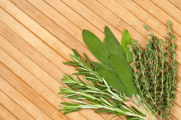 Collection of fresh herbs for cooking isolated on wooden backgro