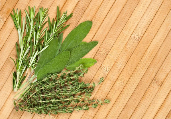 Collection d'herbes fraîches pour la cuisson isolée sur fond en bois — Photo