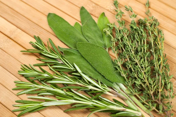 Collection d'herbes fraîches pour la cuisson isolée sur fond en bois — Photo