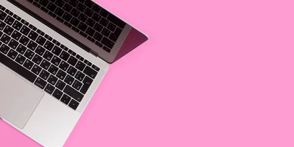 Beauty office desk with laptop notebook on pink background top view