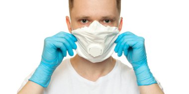 Lateks koruyucu eldivenli genç cerrah beyaz arka plana beyaz koruma maskesi takıyor. Tıbbi eldivenli ve koruyucu maskeli bir adam. Coronavirus COVID-19 koruması