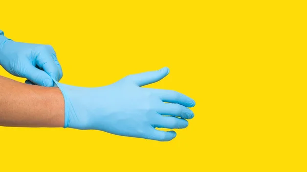 Доктор Надевает Защитные Голубые Перчатки Изолированные Желтом Фоне Копирование Пространства — стоковое фото